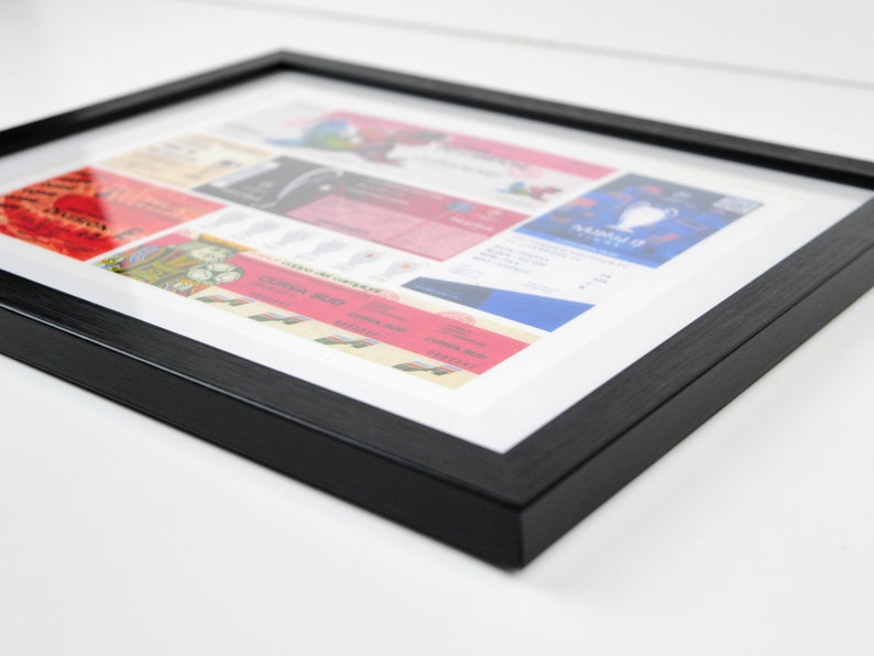 May include: A black framed picture with a white mat showcasing a collection of vintage concert tickets. The tickets are arranged in a collage style and feature various bands and events.