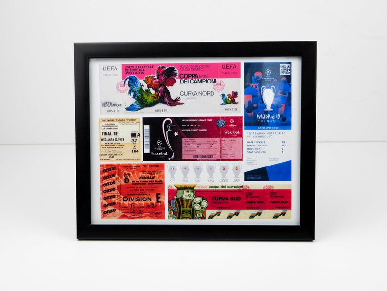 May include: A framed collage of vintage soccer tickets and memorabilia. The tickets are from different European teams and tournaments, including the UEFA Champions League and the Coppa dei Campioni. The collage also includes a small trophy and a rooster graphic.