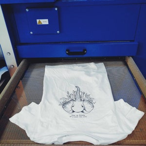 May include: A white t-shirt with a black and white illustration of two elephants with the text "Trees are saying oh I pity the ones".