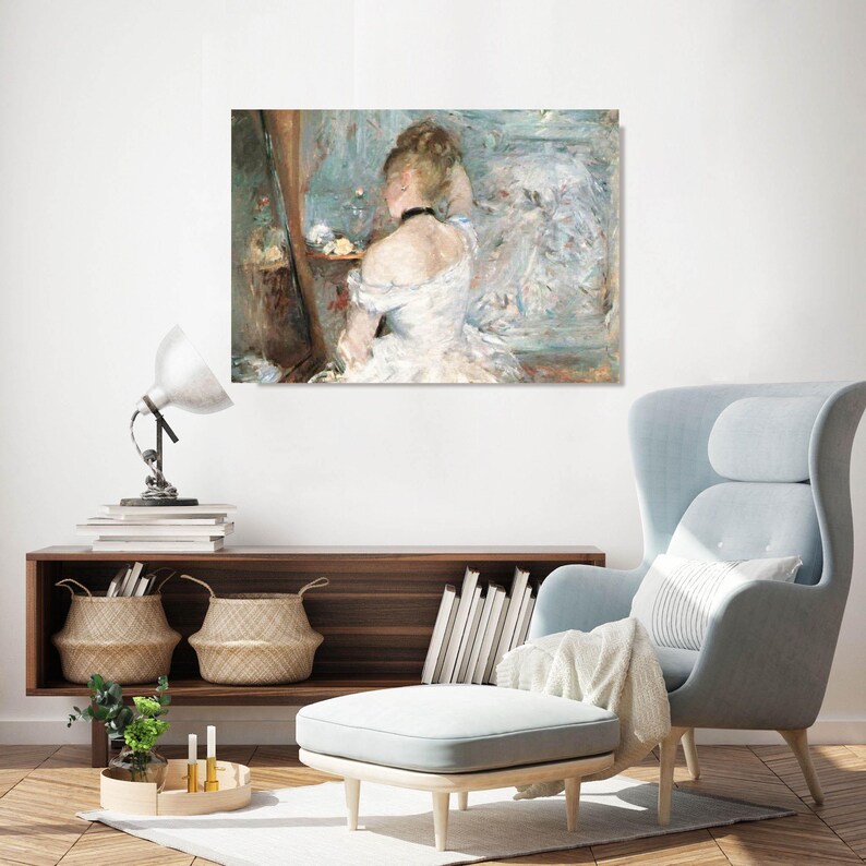 May include: A framed print of a woman in a white dress, viewed from the back, looking into a mirror. The artwork has a soft, impressionistic style with a muted color palette of blues, whites, and browns. The woman is wearing a black choker.
