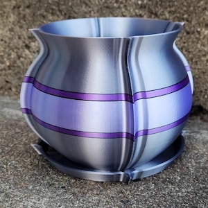 May include: A silver and purple planter with a unique, wavy design. The planter has a wide base and a narrow top, with a smooth, metallic finish.