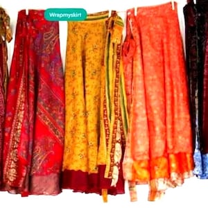 May include: Five colorful wrap skirts hanging on a clothesline. The skirts are made of different fabrics and patterns, including red, yellow, orange, and purple. The skirts are all long and flowy, and they would be perfect for a summer day.