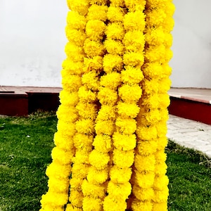 K&ouml;nnte beinhalten: Eine lange Girlande aus leuchtend gelben Ringelblumen, perfekt f&uuml;r die Dekoration eines Hauses oder einer Veranstaltung.