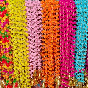 Könnte beinhalten: Eine Sammlung bunter Girlanden aus Pompons mit goldenen Glöckchen am Ende. Die Girlanden sind in verschiedenen Farben, darunter Rot, Orange, Gelb, Grün, Blau, Lila und Pink.