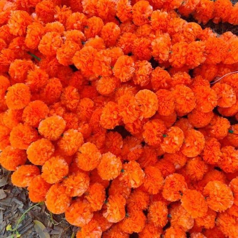 K&ouml;nnte beinhalten: Ein gro&szlig;er Strau&szlig; leuchtend orangefarbener k&uuml;nstlicher Ringelblumen. Die Blumen sind in einem dichten B&uuml;schel angeordnet und bilden ein lebendiges und farbenfrohes Bild.
