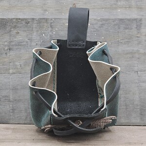 Small leather belt pouch with a silver scaled dragon hand sewn on the front. The main body is the color of your choice (green or red). The bag has a drawstring closure.