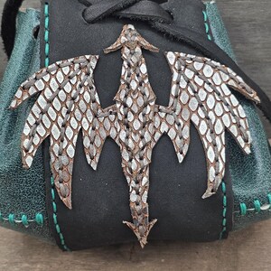 Each pouch features a silver-embossed leather dragon hand sewn on the front.