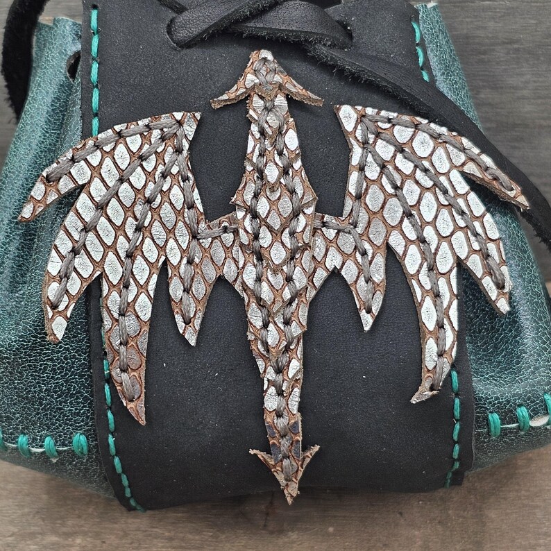Each pouch features a silver-embossed leather dragon hand sewn on the front.