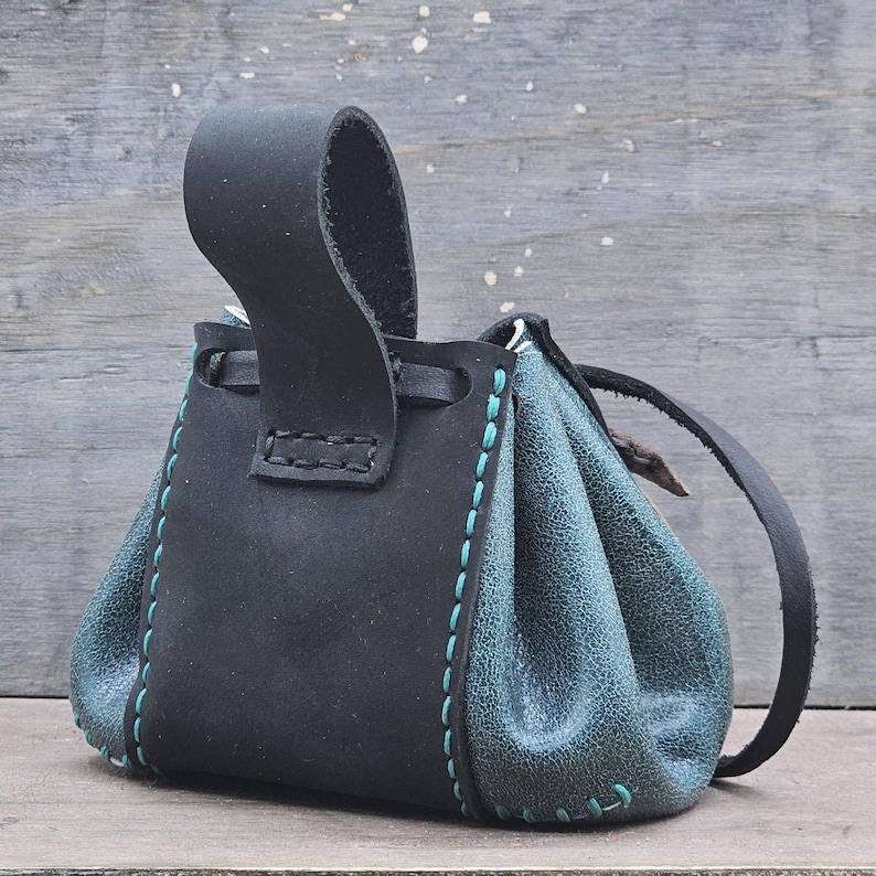 The bag has a belt loop attachment for your belt to slip through and hold. This pouch is small and great for Renaissance Fairs.