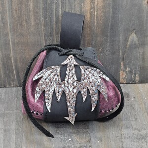 Small leather belt pouch with a silver scaled dragon hand sewn on the front. The main body is the color of your choice (green or red). The bag has a drawstring closure.