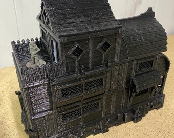May include: A black, 3D-printed model of a multi-storey building with a detailed, textured exterior. The building features a sloped roof, diamond-shaped windows, and a small figure on a balcony. The model is designed to resemble a medieval structure.