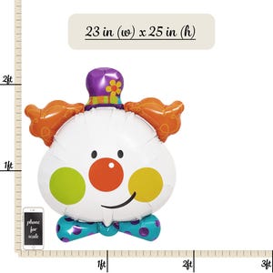 May include: A large white clown balloon with orange hair, a purple hat with a yellow flower, and a red nose. The balloon has green and yellow circles on the cheeks and a blue bow tie. The balloon is 23 inches wide and 25 inches tall.