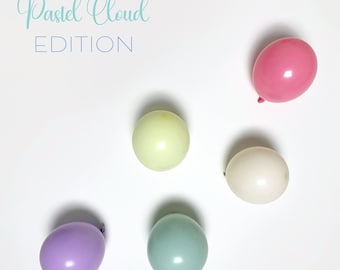 Kit de arco de guirnalda de globos arcoíris con nubes pastel. Tonos suaves y apagados: rosa claro, amarillo, menta y lila. Primer cumpleaños de niña, revelación de género neutral.