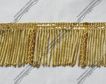 May include: Gold fringe trim with a woven pattern. The fringe is approximately 1 inch long.
