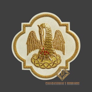 May include: A gold embroidered patch with a pelican feeding its young with its own blood. The patch is on a white background and has a gold border. The text "PASAMANERIAS Y BORDADOS" is at the bottom of the patch.
