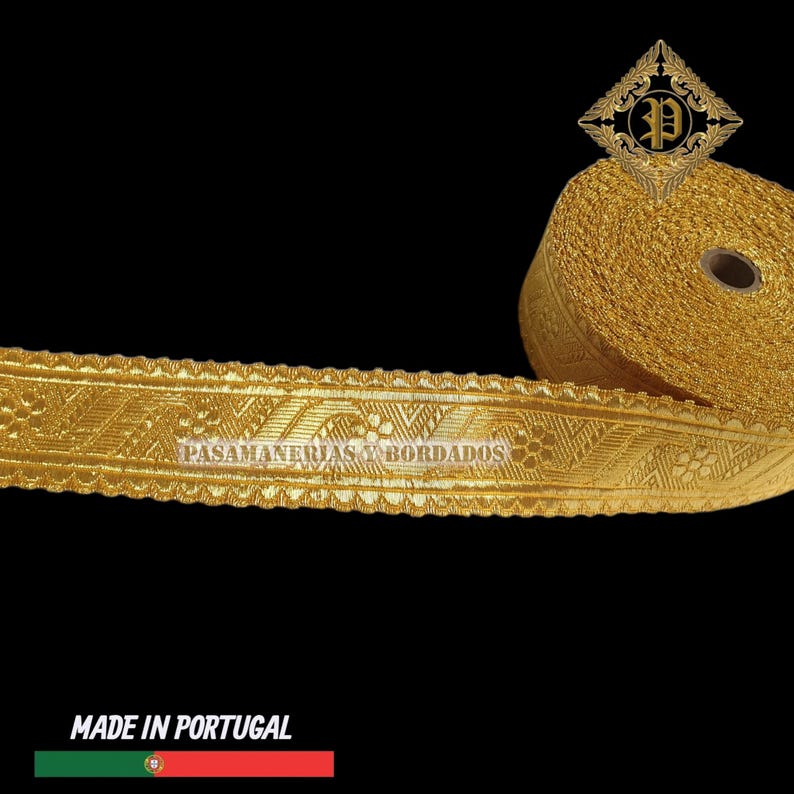 May include: Gold-colored decorative trim with intricate geometric patterns. The trim is rolled on a spool, with a section unrolled to display the design. The text "PASAMANERIAS Y BORDADOS" is visible on the trim. The words "MADE IN PORTUGAL" are at the bottom.