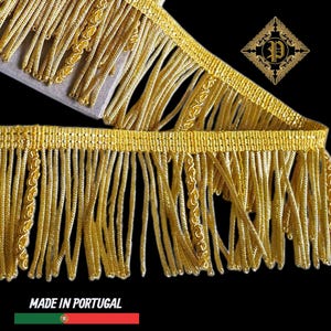 Può includere: Primo piano di passamaneria con frange dorate con una parte superiore intrecciata e lunghe ciocche pendenti. La passamaneria presenta cuciture decorative ed è ambientata su uno sfondo nero. Il testo "MADE IN PORTUGAL" è visibile in basso.