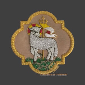 May include: A gold embroidered patch with a white lamb standing on a green field. The lamb has a halo and a banner behind it. The patch is surrounded by a gold border and has the text "Bordados y Bordados" at the bottom.