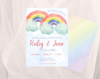 May include: A watercolor invitation with two rainbows, clouds, and text. The invitation reads "Ruby & June are turning ONE!" with event details. The design features pastel colors and a soft, dreamy aesthetic.