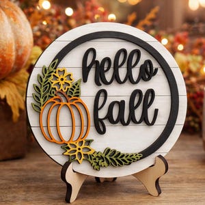 以下が含まれることがあります： 黒い持ち手と「But First, Coffee」のテキストが黒い太字で書かれた白いセラミックマグ。マグは木製の表面に置かれています。マグの高さは約10cmです。