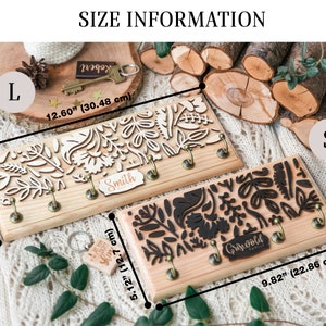 May include: Two wooden key holders with a floral design. The larger key holder is 12.60 inches by 5.12 inches and the smaller key holder is 9.82 inches by 5.12 inches. The larger key holder has the name "Smith" on it and the smaller key holder has the name "Griswold Family" on it.