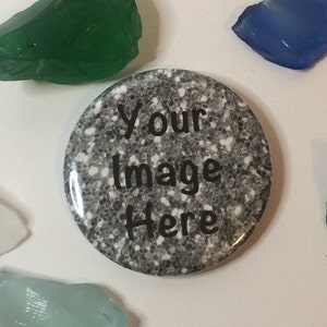 May include: A round button with a glittery gray and white design and the text "Your Image Here" in black. The button is surrounded by pieces of colorful sea glass in shades of green, blue, and white.