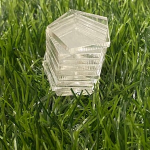 May include: A stack of clear acrylic hexagon-shaped tiles.