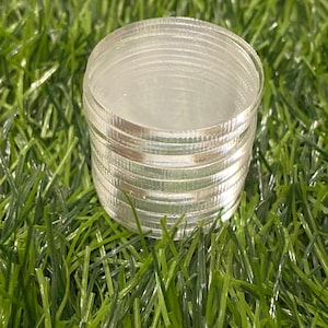 May include: A stack of clear plastic circles, likely for crafting or other projects.