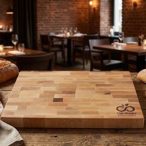 May include: A rectangular wooden cutting board with a light-colored, block-style design. The board has the logo "Culinary Solutions" on the lower right corner. Sliced bread and a bowl of oil are on the wooden table.