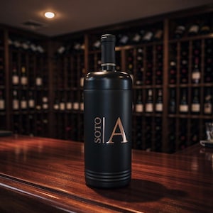 May include: A black wine bottle with gold accents and the word "SOTO" and the letter "A" in gold lettering. The bottle is on a wooden surface, with a wine rack in the background.
