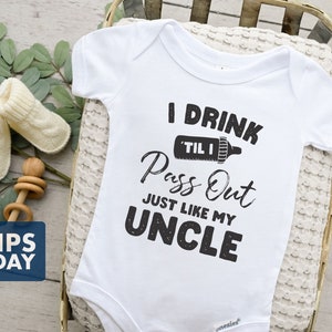 May include: White baby onesie with black text that reads "I drink til I pass out just like my uncle". The onesie has a small image of a baby bottle with a measuring line that reads "til I".