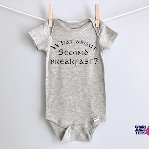 May include: A gray baby onesie with the text "What about second breakfast?" printed in black.