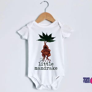 May include: White baby onesie with a brown mandrake illustration and the text "little mandrake".