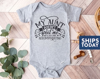 May include: Gray baby onesie with black text that reads "My Aunt Doesn't Spoil Me She Is Just Very Accommodating".