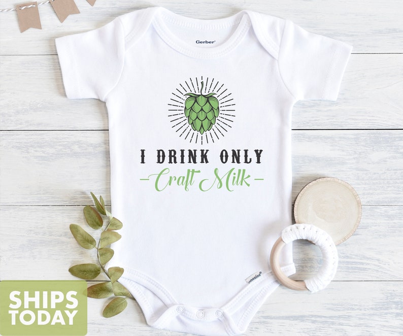 May include: White baby onesie with a green hop cone graphic and the text "I drink only -Craft Milk- "