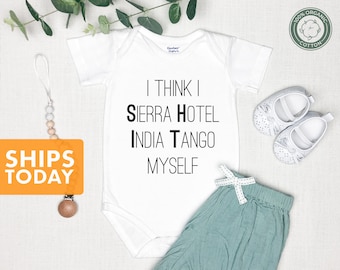 May include: White baby onesie with black text that reads "I think I Sierra Hotel India Tango Myself". The onesie is on a white background with a pair of white baby shoes and a light blue baby skirt.