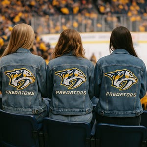 Può includere: Tre giacche di jeans con il logo dei Predators di Nashville sul retro. Il logo presenta una tigre dai denti a sciabola in giallo, bianco e blu navy. La parola "PREDATORS" è stampata sotto in bianco.