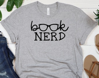 May include: A gray t-shirt with the text "book nerd" in black lettering. The text includes a pair of glasses as part of the word "book".