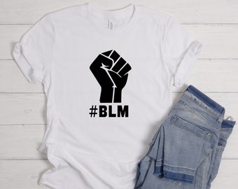 May include: White t-shirt with a black raised fist graphic and the text "#BLM" printed on the front.