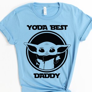 K&ouml;nnte beinhalten: Hellblaues T-Shirt mit einer schwarzen Grafik eines Star Wars-Charakters, Yoda, mit dem Text "Yoda Best Daddy".
