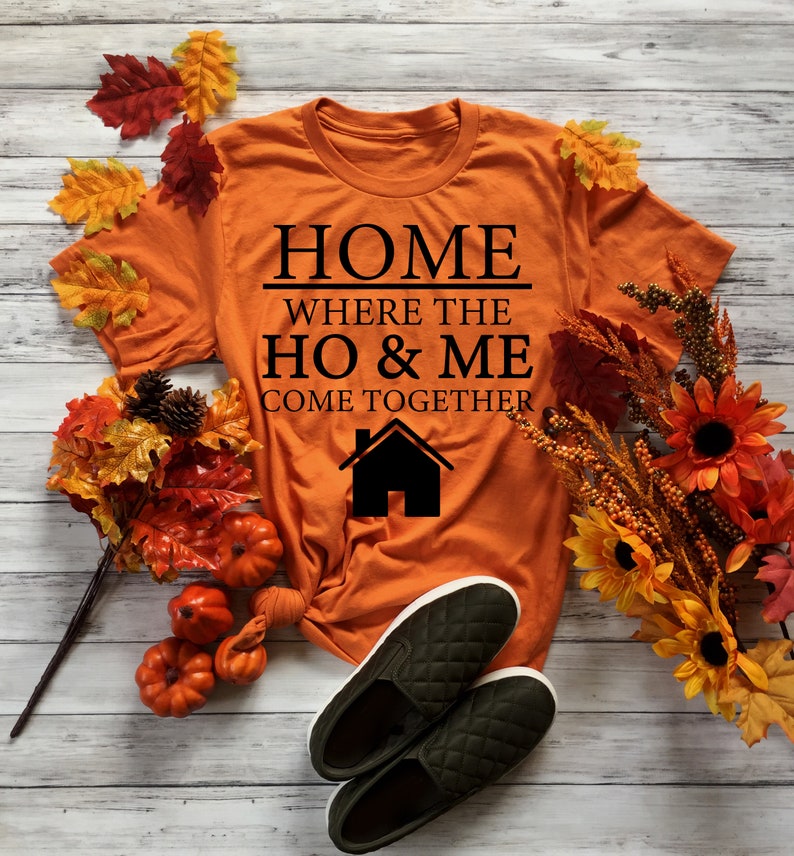 May include: Orange t-shirt with black text that reads "Home where the ho & me come together" and a black house icon.