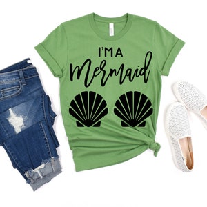 May include: A green t-shirt with the text "I'm a Mermaid" in black script and two black seashells on the bottom.