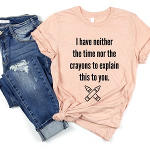 May include: A light pink t-shirt with the text "I have neither the time nor the crayons to explain this to you." and a drawing of two crossed crayons.