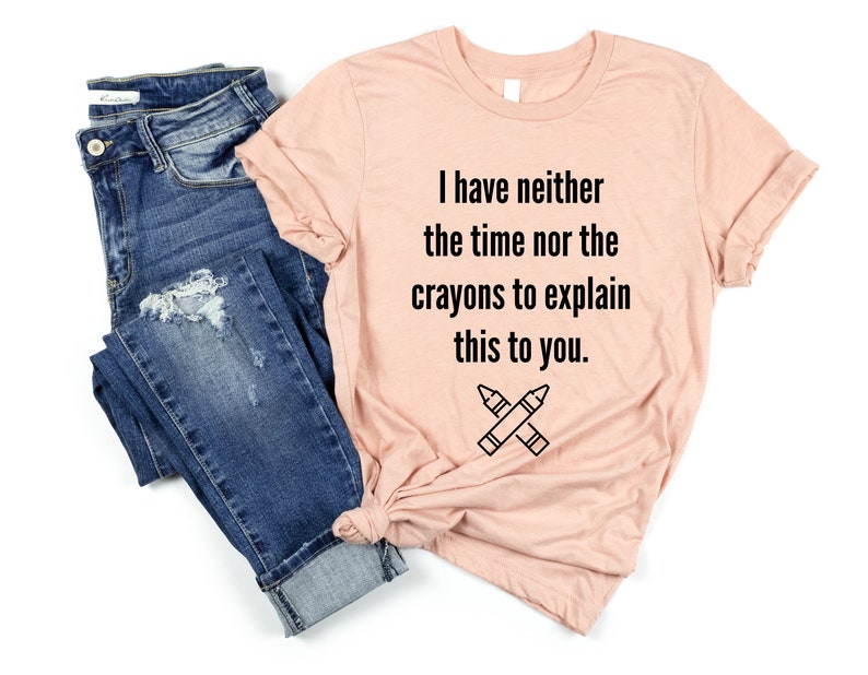 May include: A light pink t-shirt with the text "I have neither the time nor the crayons to explain this to you." and a drawing of two crossed crayons.
