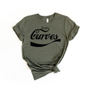 May include: A green t-shirt with the text "Enjoy Curves" in a black, stylized font.