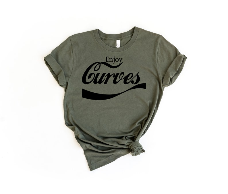 May include: A green t-shirt with the text "Enjoy Curves" in a black, stylized font.