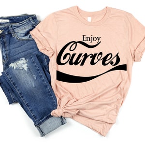 May include: A peach-colored t-shirt with the text "Enjoy Curves" in a black, stylized font that resembles a popular soda brand logo.