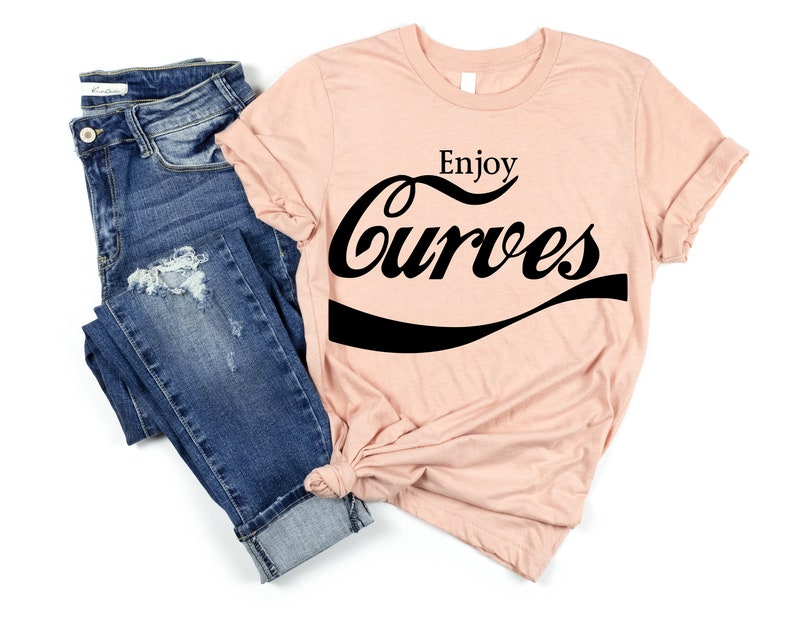 May include: A peach-colored t-shirt with the text "Enjoy Curves" in a black, stylized font that resembles a popular soda brand logo.