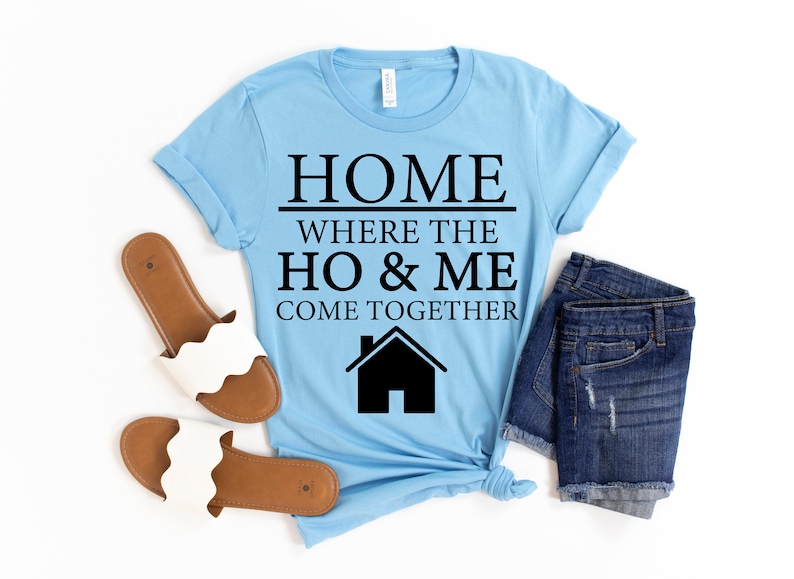 May include: Light blue t-shirt with black text that reads "Home where the ho & me come together" and a black silhouette of a house.