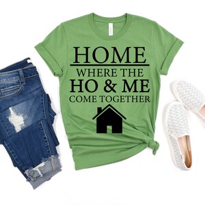May include: Green t-shirt with black text that reads "Home where the ho & me come together" and a black house icon.
